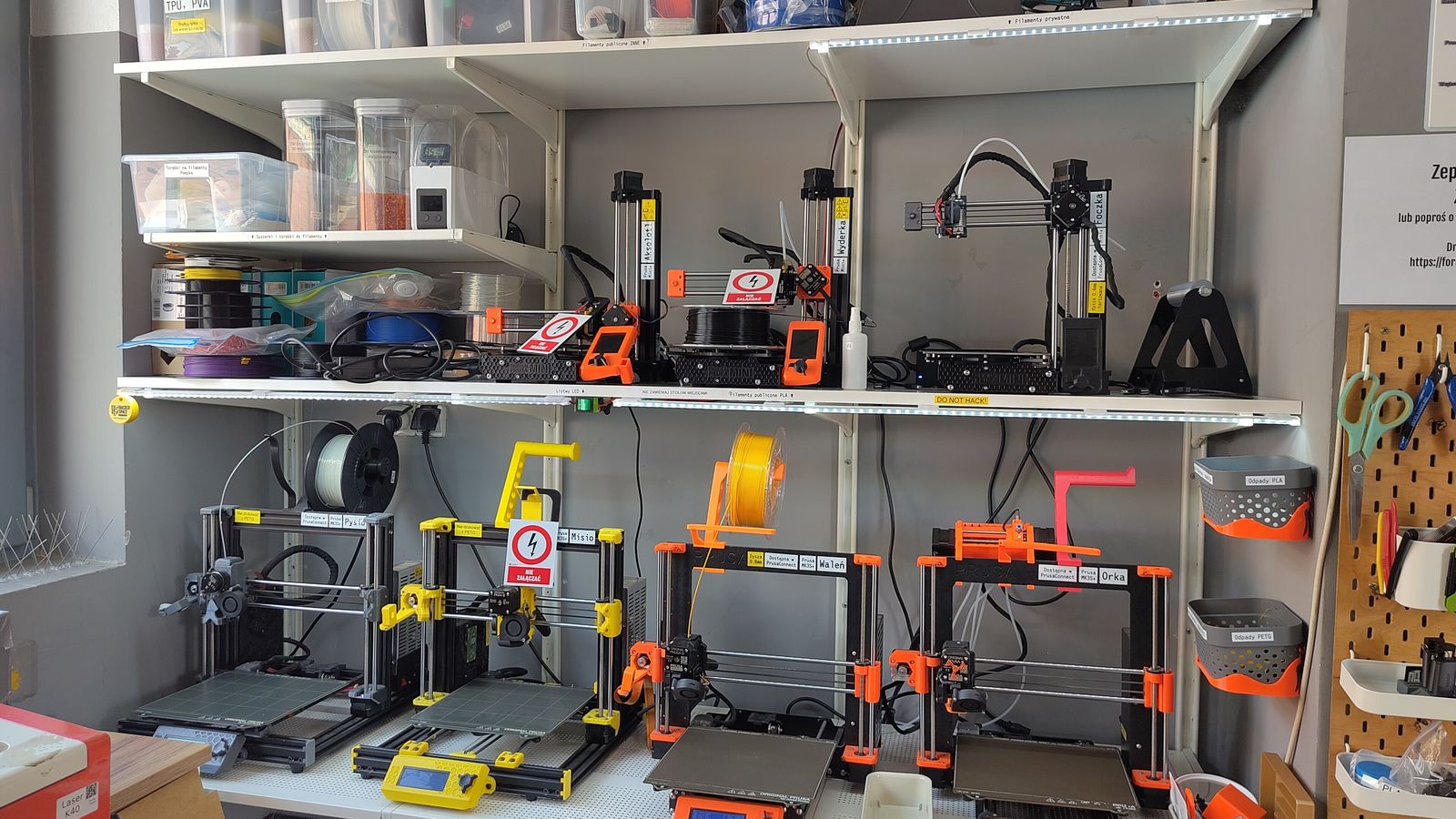 Étagères chargées d'une dizaine d'imprimantes 3D à filament et de bobines