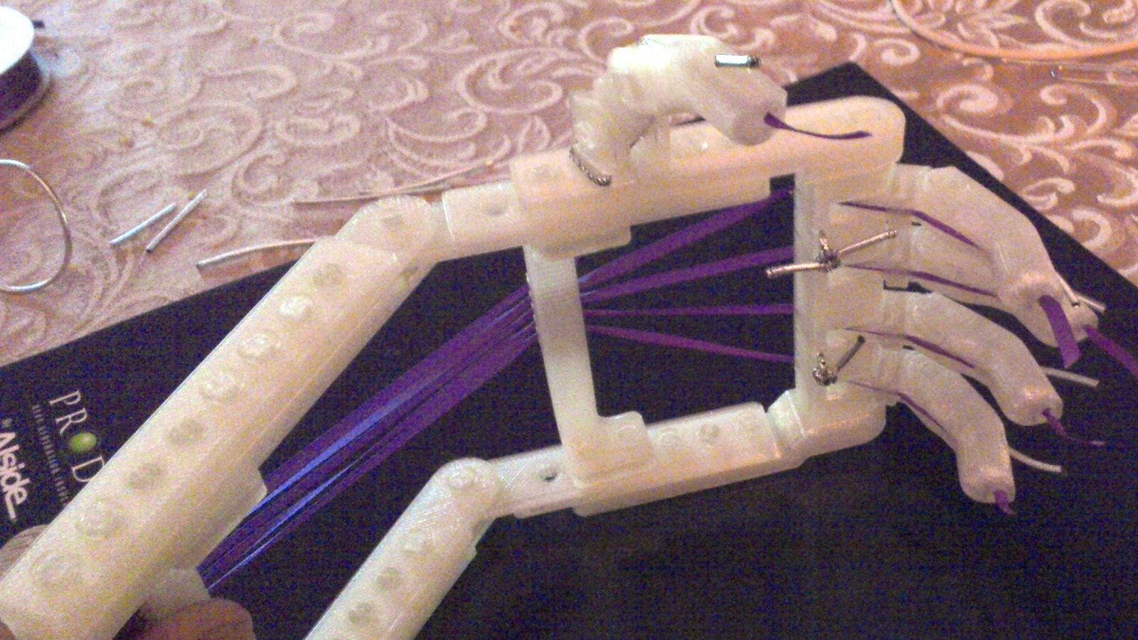 Prototype de main articulée imprimé en 3D, doigts actionnés par des fils